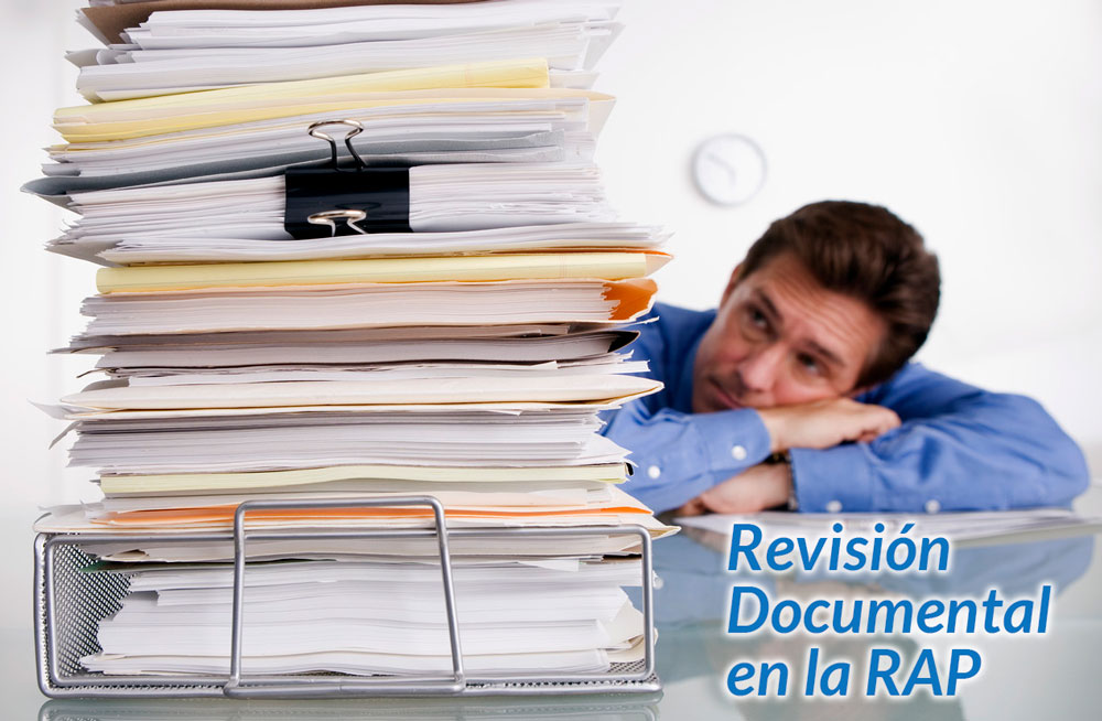 Hombre apoyado en el escritorio frente a una pila alta de expedientes, con el texto Revisión Documental en la RAP